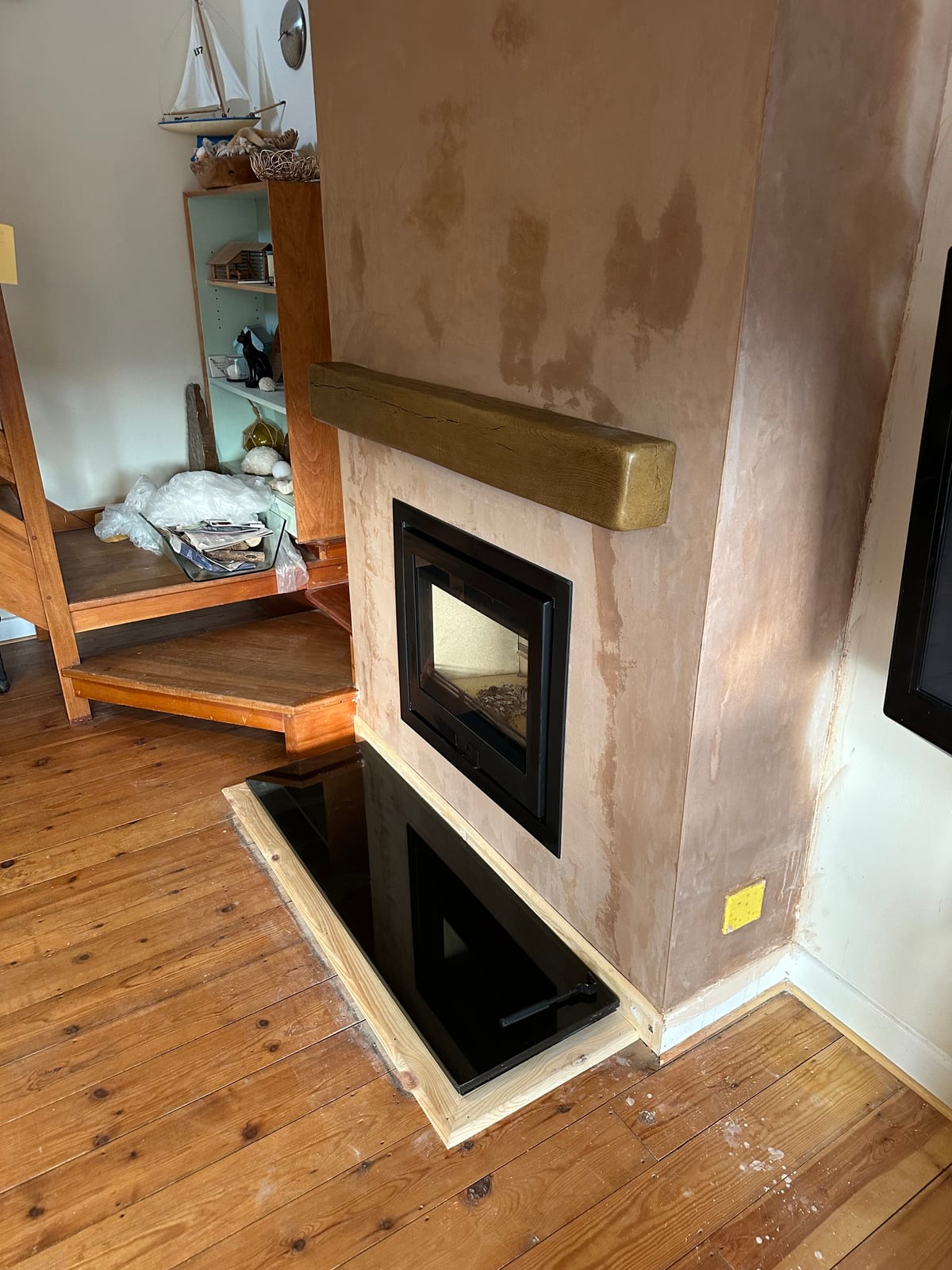 Inset wood-burning stove with timber mantel and black hearth